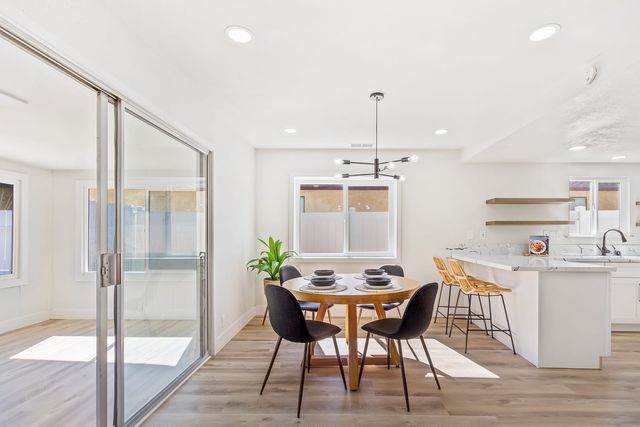 Kitchen and dining area with a round table beside full-height sliding glass doors