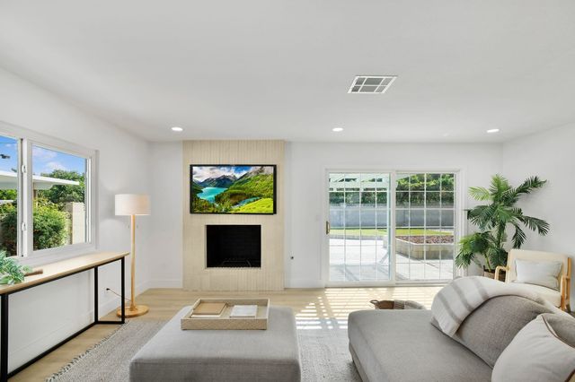 Living room with a fireplace wall, a sectional sofa and sliding doors to the patio