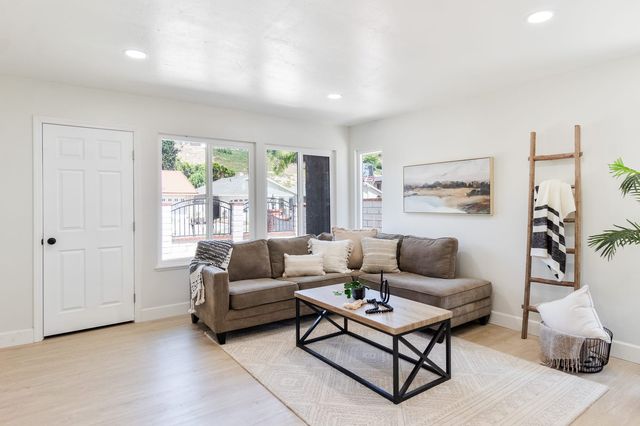 Living room with a sofa, a coffee table and windows on two walls