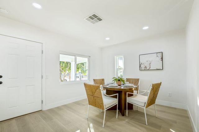 Breakfast nook with a round table and four chairs beside a window and a door