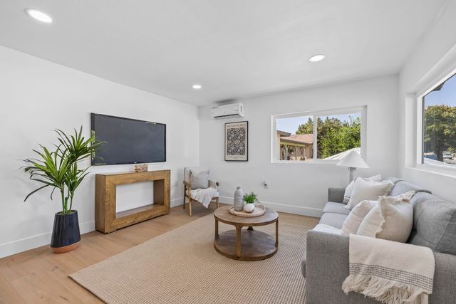 Living room with a gray sofa, a round coffee table and a window to the side yard