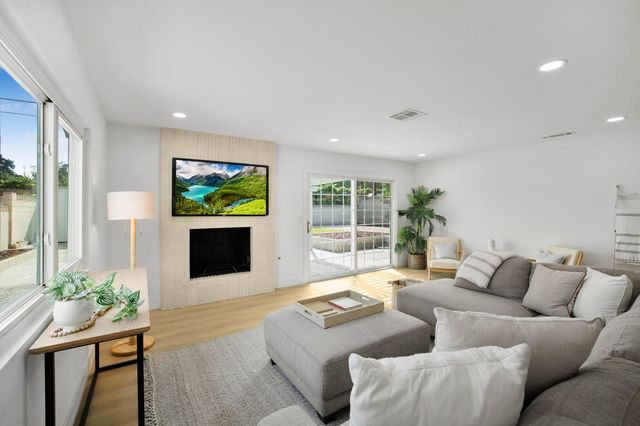 Family room with a sectional sofa, a fireplace wall and sliding glass doors to the patio