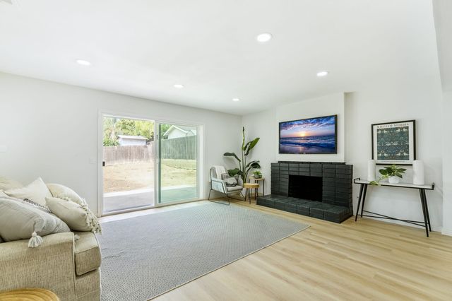 Living room with a black brick fireplace and a sliding door to the back yard