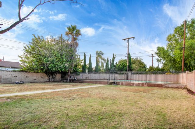 Back yard and block wall with neighboring single-story homes beyond